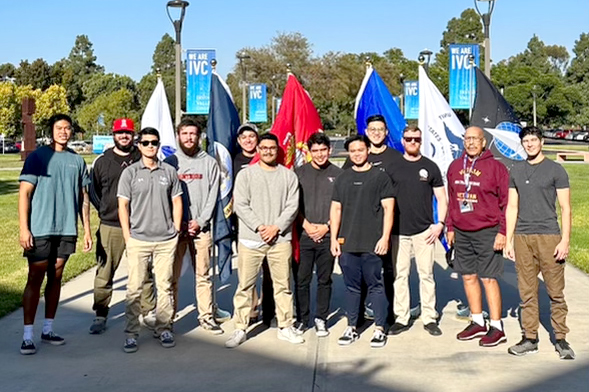 Photo of a group of veterans standing in front of flags