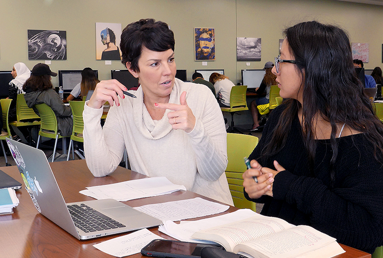 Writing center teacher speaking to student 